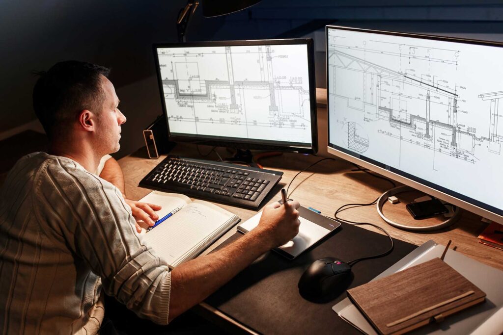 Man starring at monitors with CAD drawings