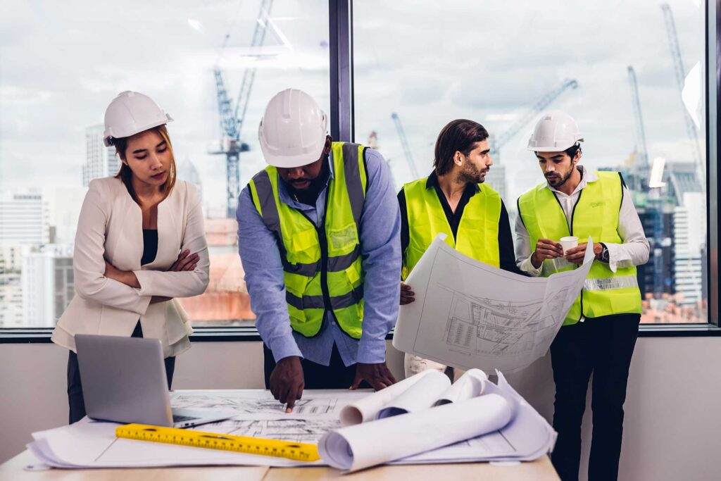 team engineers with draft plan of building on construction